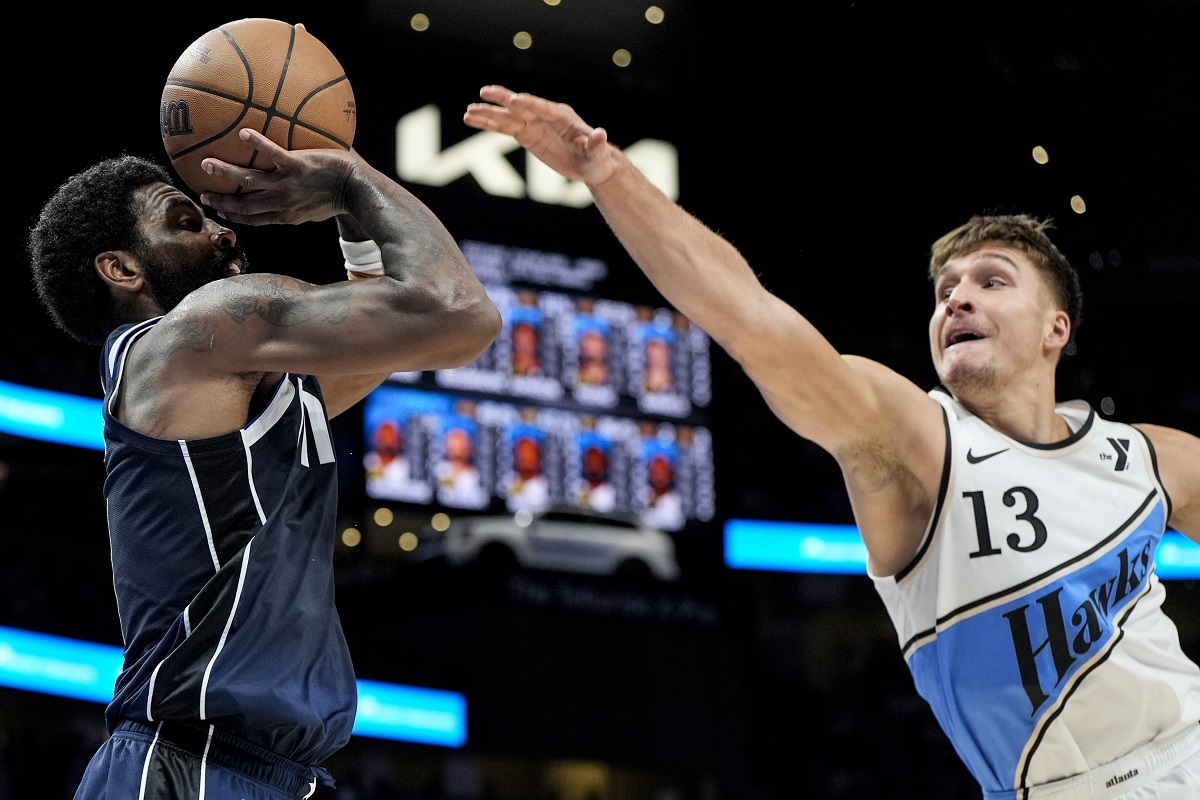 Dallas Mavericks guard Kyrie Irving (11) shoots against Atlanta Hawks guard Bogdan Bogdanovic (13) during the second half of an NBA basketball game, Monday, Nov. 25, 2024, in Atlanta. (AP Photo/Mike Stewart)