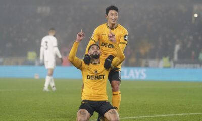 Wolverhampton Wanderers' Matheus Cunha, front, celebrates after Hwang Hee-Chan, top, scored their side's second goal during the English Premier League soccer match between Wolverhampton Wanderers and Manchester United at the Molineux Stadium, Wolverhampton, England, Thursday, Dec. 26, 2024. (David Davies/PA via AP)