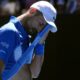 Novak Djokovic of Serbia wipes the sweat from his face during his semifinal match against Alexander Zverev of Germany at the Australian Open tennis championship in Melbourne, Australia, Friday, Jan. 24, 2025. (AP Photo/Asanka Brendon Ratnayake)