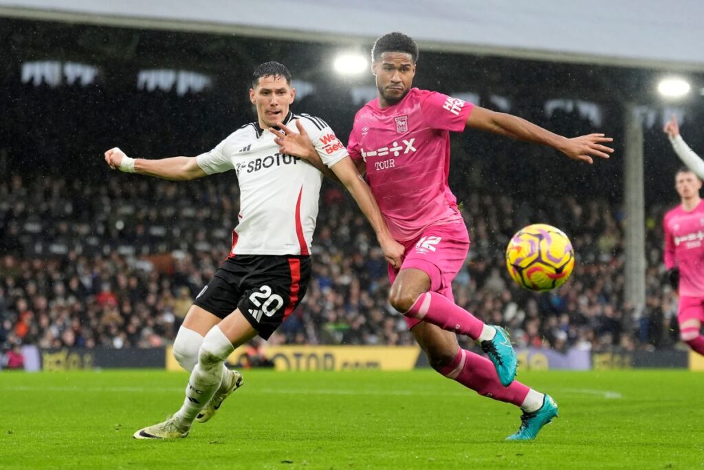 Fulham's Sasa Lukic, left, and Ipswich Town's Jens Cajuste battle for the ball during the English Premier League soccer match between Fulham and Ipswich Town at Craven Cottage stadium, London, Sunday Jan. 5, 2025. (Andrew Matthews/PA via AP)