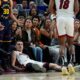 Miami Heat forward Nikola Jovic, bottom, reacts after making a 3-point basket and being fouled by Golden State Warriors guard Stephen Curry (30) during the second half of an NBA basketball game Tuesday, Jan. 7, 2025, in San Francisco. (AP Photo/Godofredo A. Vásquez)