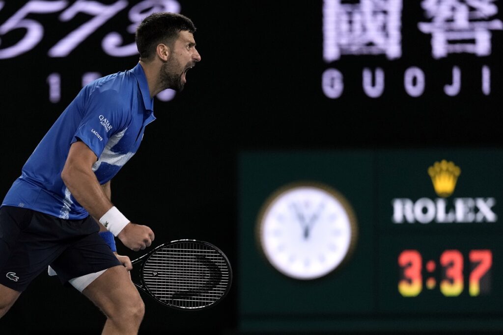 Novak Djokovic of Serbia celebrates after defeating Carlos Alcaraz of Spain in their quarterfinal match at the Australian Open tennis championship in Melbourne, Australia, early Wednesday, Jan. 22, 2025. (AP Photo/Ng Han Guan)