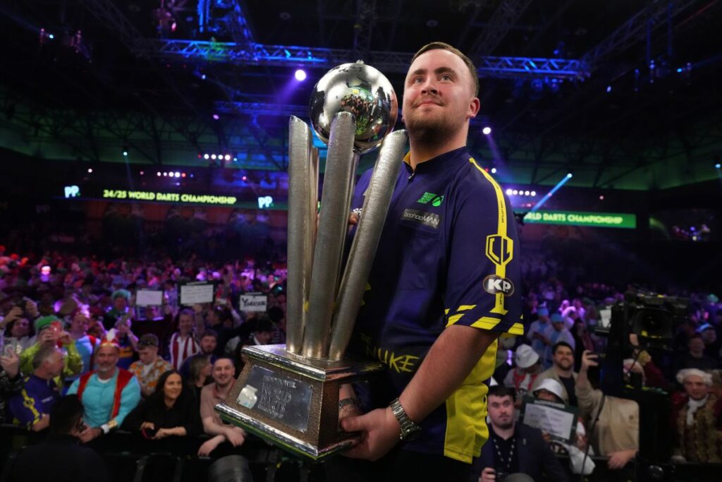 Luke Littler of England holds the trophy after winning the final against Michael van Gerwen of the Netherlands at the World Darts Championship at Alexandra Palace in London, Friday, Jan. 3, 2025. (AP Photo/Kirsty Wigglesworth)