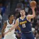 Denver Nuggets center Nikola Jokic, front, fields a pass as Brooklyn Nets center Nic Claxton defends in the first half of an NBA basketball game Friday, Jan. 10, 2025, in Denver. (AP Photo/David Zalubowski)