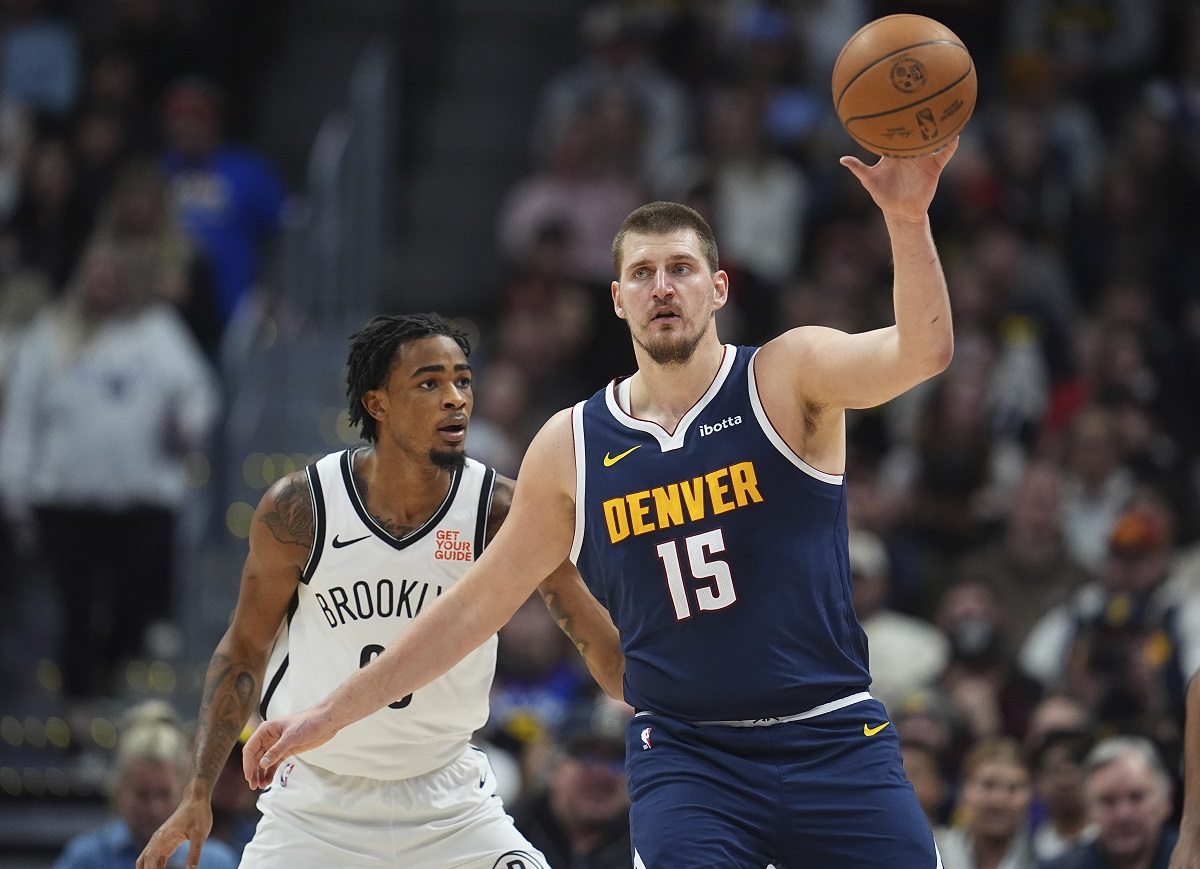 Denver Nuggets center Nikola Jokic, front, fields a pass as Brooklyn Nets center Nic Claxton defends in the first half of an NBA basketball game Friday, Jan. 10, 2025, in Denver. (AP Photo/David Zalubowski)