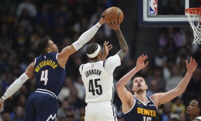 Brooklyn Nets guard Keon Johnson (45) has his shot blocked by Denver Nuggets guard Russell Westbrook (4) as center Nikola Jokic (15) covers in the second half of an NBA basketball game Friday, Jan. 10, 2025, in Denver. (AP Photo/David Zalubowski)