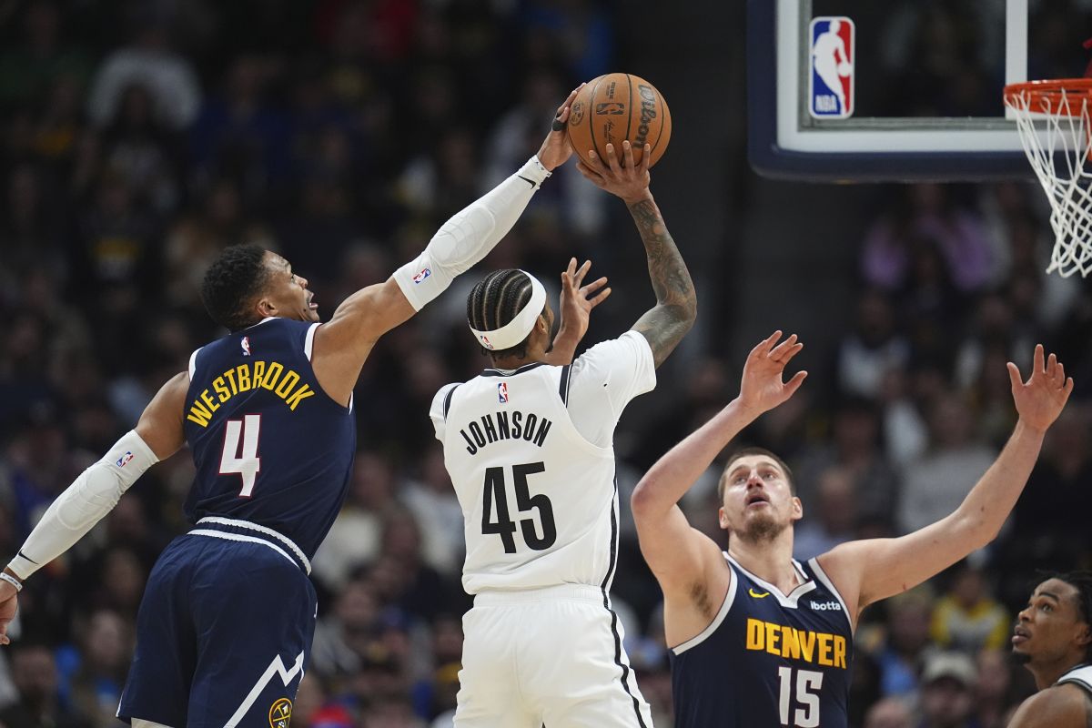 Brooklyn Nets guard Keon Johnson (45) has his shot blocked by Denver Nuggets guard Russell Westbrook (4) as center Nikola Jokic (15) covers in the second half of an NBA basketball game Friday, Jan. 10, 2025, in Denver. (AP Photo/David Zalubowski)