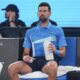 Serbia's Novak Djokovic takes a drink during a break in his exhibition match against Germany's Alexander Zverev ahead of the Australian Open tennis championship in Melbourne, Australia, Thursday, Jan. 9, 2025. (AP Photo/Vincent Thian)