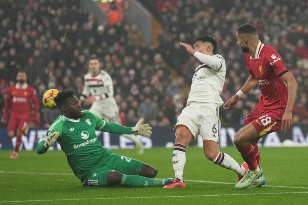 Liverpool's Cody Gakpo, right, Manchester United's Lisandro Martinez, center, and goalkeeper Andre Onana battle for the ball during the English Premier League soccer match at the Anfield stadium in Liverpool, England, Sunday, Jan. 5, 2025. (AP Photo/Jon Super)