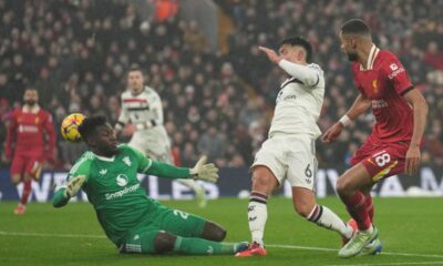 Liverpool's Cody Gakpo, right, Manchester United's Lisandro Martinez, center, and goalkeeper Andre Onana battle for the ball during the English Premier League soccer match at the Anfield stadium in Liverpool, England, Sunday, Jan. 5, 2025. (AP Photo/Jon Super)