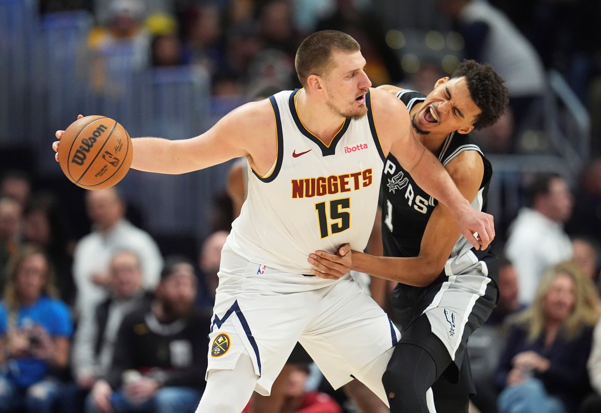 Denver Nuggets center Nikola Jokic, looks to pass the ball as San Antonio Spurs center Victor Wembanyama defends in the second half of an NBA basketball game Friday, Jan. 3, 2025, in Denver. (AP Photo/David Zalubowski)