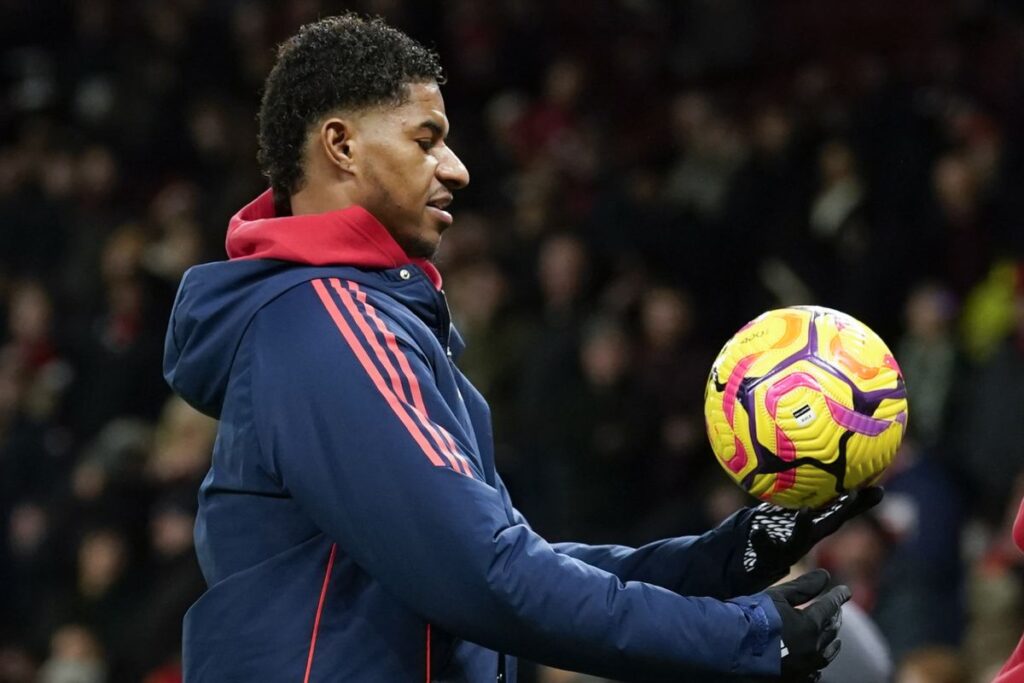 Manchester United's Marcus Rashford holds the ball during the warm up before the English Premier League soccer match between Manchester United and Newcastle at the Old Trafford stadium in Manchester, England, Monday, Dec. 30, 2024. (AP Photo/Dave Thompson)