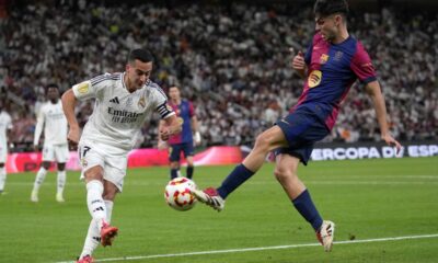 Real Madrid's Lucas Vazquez, left, challenges for the ball with Barcelona's Pedri during the Spain Super Cup final soccer match between Real Madrid and Barcelona at King Abdullah Stadium in Jeddah, Saudi Arabia, Sunday, Jan. 12, 2025. (AP Photo/Altaf Qadri)