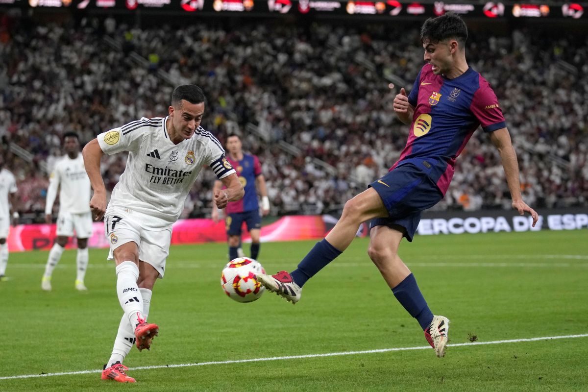 Real Madrid's Lucas Vazquez, left, challenges for the ball with Barcelona's Pedri during the Spain Super Cup final soccer match between Real Madrid and Barcelona at King Abdullah Stadium in Jeddah, Saudi Arabia, Sunday, Jan. 12, 2025. (AP Photo/Altaf Qadri)