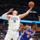 Denver Nuggets center Nikola Jokic, left, pulls in a rebound over Philadelphia 76ers guard Tyrese Maxey in the second half of an NBA basketball game Tuesday, Jan. 21, 2025, in Denver. (AP Photo/David Zalubowski)