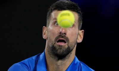 Novak Djokovic of Serbia plays a backhand return to Carlos Alcaraz of Spain during their quarterfinal match at the Australian Open tennis championship in Melbourne, Australia, Tuesday, Jan. 21, 2025. (AP Photo/Asanka Brendon Ratnayake)