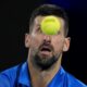 Novak Djokovic of Serbia plays a backhand return to Carlos Alcaraz of Spain during their quarterfinal match at the Australian Open tennis championship in Melbourne, Australia, Tuesday, Jan. 21, 2025. (AP Photo/Asanka Brendon Ratnayake)