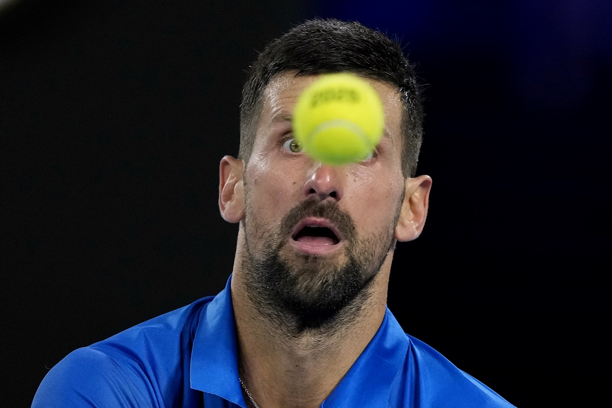 Novak Djokovic of Serbia plays a backhand return to Carlos Alcaraz of Spain during their quarterfinal match at the Australian Open tennis championship in Melbourne, Australia, Tuesday, Jan. 21, 2025. (AP Photo/Asanka Brendon Ratnayake)