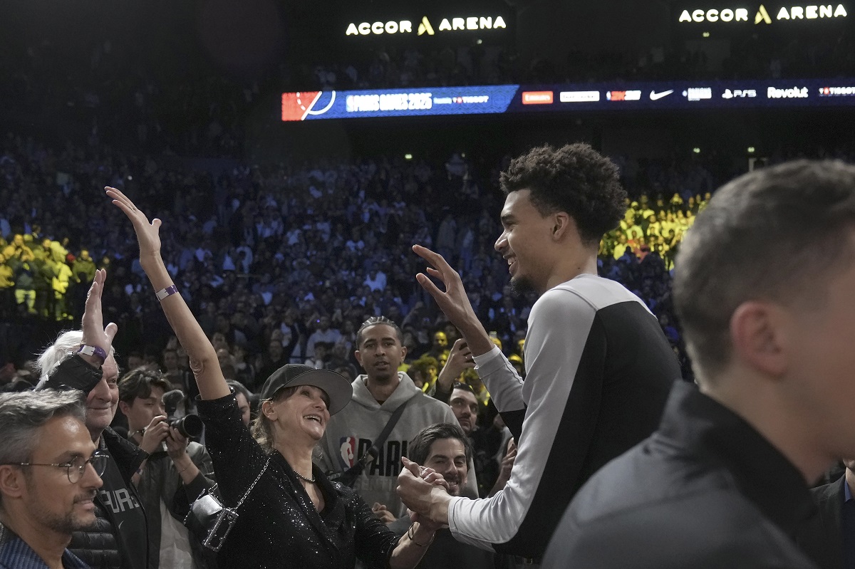 San Antonio Spurs center Victor Wembanyama, middle right, celebrates with fans after a Paris Games 2025 NBA basketball game between the Indiana Pacers and the Spurs in Paris, Thursday, Jan. 23, 2025. (AP Photo/Thibault Camus)