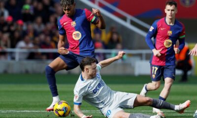 Barcelona's Lamine Yamal, left, is challenged by Alaves' Tomas Conechny during a Spanish La Liga soccer match between Barcelona and Alaves at the Lluis Companys Olympic Stadium in Barcelona, Spain, Sunday Feb. 2, 2025. (AP Photo/Joan Monfort)