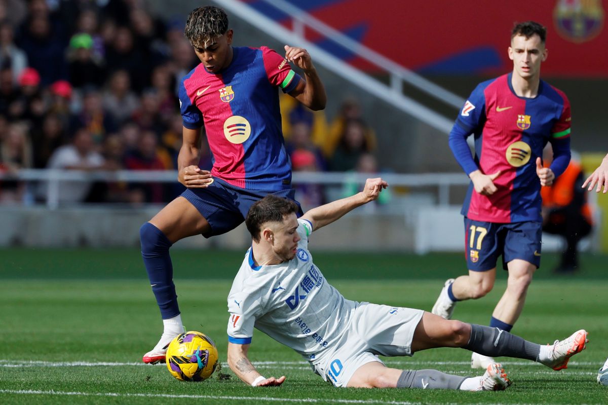 Barcelona's Lamine Yamal, left, is challenged by Alaves' Tomas Conechny during a Spanish La Liga soccer match between Barcelona and Alaves at the Lluis Companys Olympic Stadium in Barcelona, Spain, Sunday Feb. 2, 2025. (AP Photo/Joan Monfort)