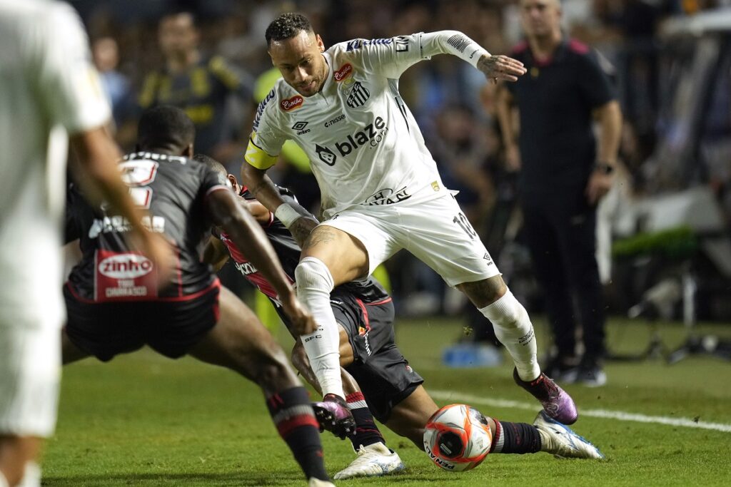 Brazil's Neymar is tackled as he chases a ball during his debut for Santos FC in a Sao Paulo league soccer match against Botafogo-SP, in Santos, Brazil, Wednesday, Feb. 5, 2025. (AP Photo/Andre Penner)