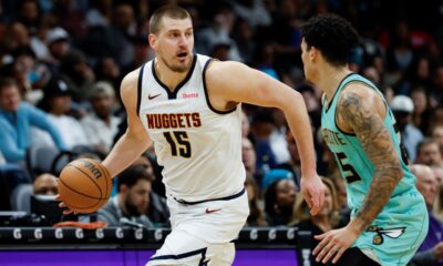 Denver Nuggets center Nikola Jokic (15) brings the ball up court against Charlotte Hornets guard KJ Simpson during the second half of an NBA basketball game in Charlotte, N.C., Saturday, Feb. 1, 2025. (AP Photo/Nell Redmond)