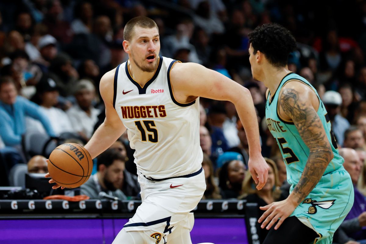 Denver Nuggets center Nikola Jokic (15) brings the ball up court against Charlotte Hornets guard KJ Simpson during the second half of an NBA basketball game in Charlotte, N.C., Saturday, Feb. 1, 2025. (AP Photo/Nell Redmond)