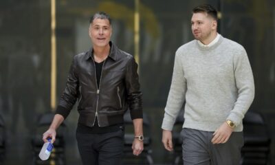 Los Angeles Lakers' Luka Doncic, left, walks to the podium with general manger Rob Pelinka during an introductory NBA basketball press conference Tuesday, Feb. 4, 2025, in El Segundo, Calif. (AP Photo/Jae C. Hong)