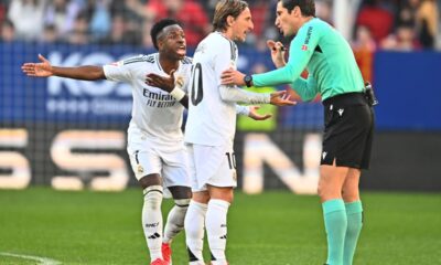 Real Madrid's Luka Modric, centre, speaks with the referee as Vinicius Junior protests during a Spanish La Liga soccer match between Osasuna and Real Madrid at El Sardar stadium in Pamplona, Spain, Saturday, Feb. 15, 2025. (AP Photo/Miguel Oses)