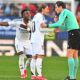 Real Madrid's Luka Modric, centre, speaks with the referee as Vinicius Junior protests during a Spanish La Liga soccer match between Osasuna and Real Madrid at El Sardar stadium in Pamplona, Spain, Saturday, Feb. 15, 2025. (AP Photo/Miguel Oses)