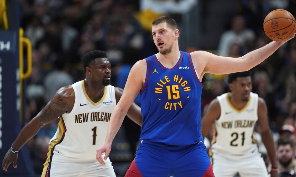 Denver Nuggets center Nikola Jokic (15) looks to pass the ball a New Orleans Pelicans forward Zion Williamson (1) defends in the second half of an NBA basketball game Monday, Feb. 3, 2025, in Denver. (AP Photo/David Zalubowski)