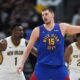 Denver Nuggets center Nikola Jokic (15) looks to pass the ball a New Orleans Pelicans forward Zion Williamson (1) defends in the second half of an NBA basketball game Monday, Feb. 3, 2025, in Denver. (AP Photo/David Zalubowski)