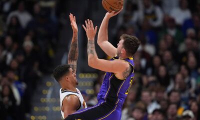 Los Angeles Lakers guard Luka Doncic, right, shoots a basket over Denver Nuggets forward Michael Porter Jr. in the second half of an NBA basketball game, Saturday, Feb. 22, 2025, in Denver. (AP Photo/David Zalubowski)