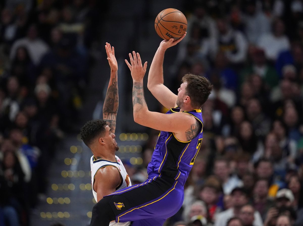 Los Angeles Lakers guard Luka Doncic, right, shoots a basket over Denver Nuggets forward Michael Porter Jr. in the second half of an NBA basketball game, Saturday, Feb. 22, 2025, in Denver. (AP Photo/David Zalubowski)