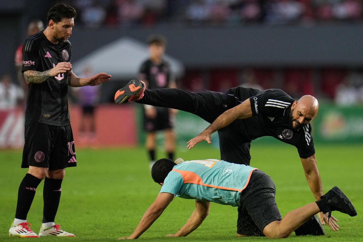 Lionel Messi's personal bodyguard tries to catch a fan who ran onto the field during a friendly soccer match between the United States' Inter Miami and Panama's Sporting San Miguelito in Panama City, Sunday, Feb. 2, 2025. (AP Photo/Matias Delacroix)