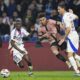 PSG's Desire Doue, center, duels for the ball with Lyon's Nemanja Matic, right, and Lyon's Sael Kumbedi during the French League One soccer match between Lyon and Paris Saint-Germain at the Groupama stadium, outside Lyon, France, Sunday, Feb. 23, 2025. (AP Photo/Laurent Cipriani)