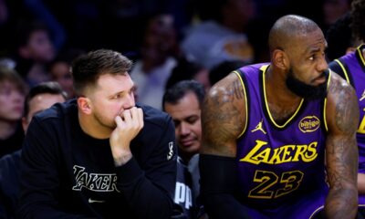 Los Angeles Lakers guard Luka Doncic, left, and forward LeBron James, right, follow the action on the floor from the bench during the first half of an NBA basketball game against the Golden State Warriors, Thursday, Feb. 6, 2025, in Los Angeles. (AP Photo/Kevork Djansezian)