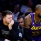 Los Angeles Lakers guard Luka Doncic, left, and forward LeBron James, right, follow the action on the floor from the bench during the first half of an NBA basketball game against the Golden State Warriors, Thursday, Feb. 6, 2025, in Los Angeles. (AP Photo/Kevork Djansezian)