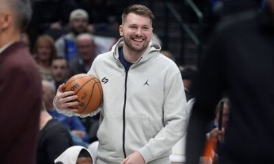 Injured Dallas Mavericks guard Luka Doncic smiles as he holds the game ball in a time out during the first half of an NBA basketball game against the Minnesota Timberwolves Wednesday, Jan. 22, 2025, in Dallas. (AP Photo/LM Otero)