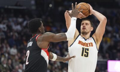 Denver Nuggets center Nikola Jokic, right, looks to shoot for a basket over Portland Trail Blazers center Deandre Ayton, left, in the first half of an NBA basketball game Monday, Feb. 10, 2025, in Denver. (AP Photo/David Zalubowski)