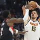 Denver Nuggets center Nikola Jokic, right, looks to shoot for a basket over Portland Trail Blazers center Deandre Ayton, left, in the first half of an NBA basketball game Monday, Feb. 10, 2025, in Denver. (AP Photo/David Zalubowski)