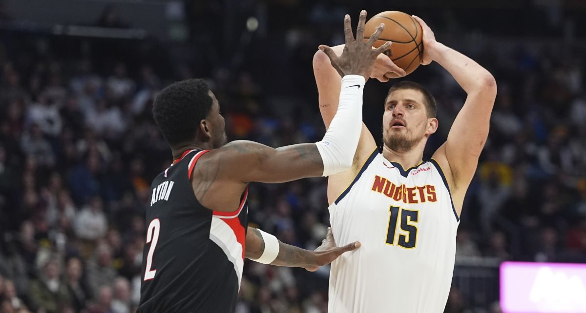 Denver Nuggets center Nikola Jokic, right, looks to shoot for a basket over Portland Trail Blazers center Deandre Ayton, left, in the first half of an NBA basketball game Monday, Feb. 10, 2025, in Denver. (AP Photo/David Zalubowski)