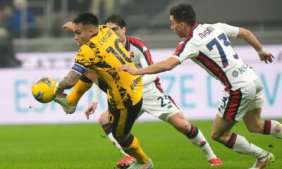 Inter Milan's Lautaro Martinez, left, challenges for the ball with Genoa's Patrizio Masini during a Serie A soccer match between Inter Milan and Genoa, at the San Siro stadium in Milan, Italy, Saturday, Feb. 22, 2025. (AP Photo/Luca Bruno)