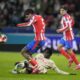 Salzburg's Moussa Yeo, on the pitch and Atletico Madrid's Rodrigo De Paul vie for the ball during the Champions League opening phase soccer match between FC Salzburg and Atletico Madrid at the Salzburg Arena in Salzburg, Austria, Wednesday, Jan. 29, 2025. (AP Photo/Matthias Schrader)