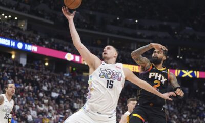 Denver Nuggets center Nikola Jokic (15) pulls in a rebound as Phoenix Suns center Nick Richards defends in the second half of an NBA basketball game Friday, March 7, 2025, in Denver. (AP Photo/David Zalubowski)