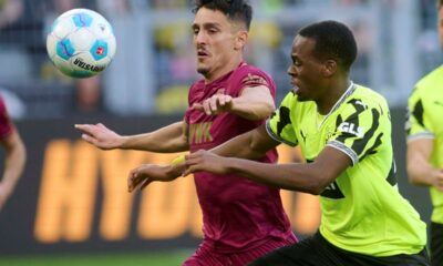 Dortmund's Jamie Gittens, right, and Augsburg's Dimitris Giannoulis in action during the German Bundesliga soccer match between Borussia Dortmund and FC Augsburg at the Signal Iduna Park in Dortmund, Germany, Saturday, March 8, 2025. (Bernd Thissen/dpa via AP)