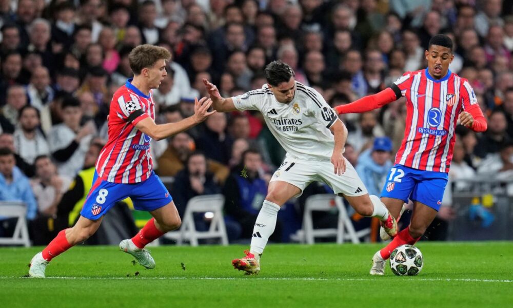 Real Madrid's Brahim Diaz, center, is challenged by Atletico Madrid's Pablo Barrios, left, and Atletico Madrid's Samuel Lino during the Champions League round of 16 first leg soccer match between Real Madrid and Atletico Madrid at the Bernebeu stadium in Madrid, Spain, Tuesday, March 4, 2025. (AP Photo/Manu Fernandez)