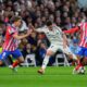 Real Madrid's Brahim Diaz, center, is challenged by Atletico Madrid's Pablo Barrios, left, and Atletico Madrid's Samuel Lino during the Champions League round of 16 first leg soccer match between Real Madrid and Atletico Madrid at the Bernebeu stadium in Madrid, Spain, Tuesday, March 4, 2025. (AP Photo/Manu Fernandez)