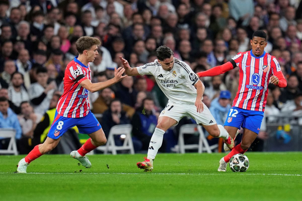 Real Madrid's Brahim Diaz, center, is challenged by Atletico Madrid's Pablo Barrios, left, and Atletico Madrid's Samuel Lino during the Champions League round of 16 first leg soccer match between Real Madrid and Atletico Madrid at the Bernebeu stadium in Madrid, Spain, Tuesday, March 4, 2025. (AP Photo/Manu Fernandez)